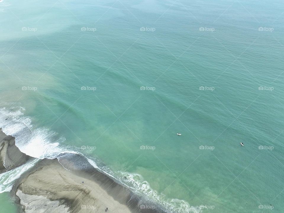 Paddle boarding out into the mighty Pacific Ocean from the beach in Laguna Beach, California on a beautiful sunny day 