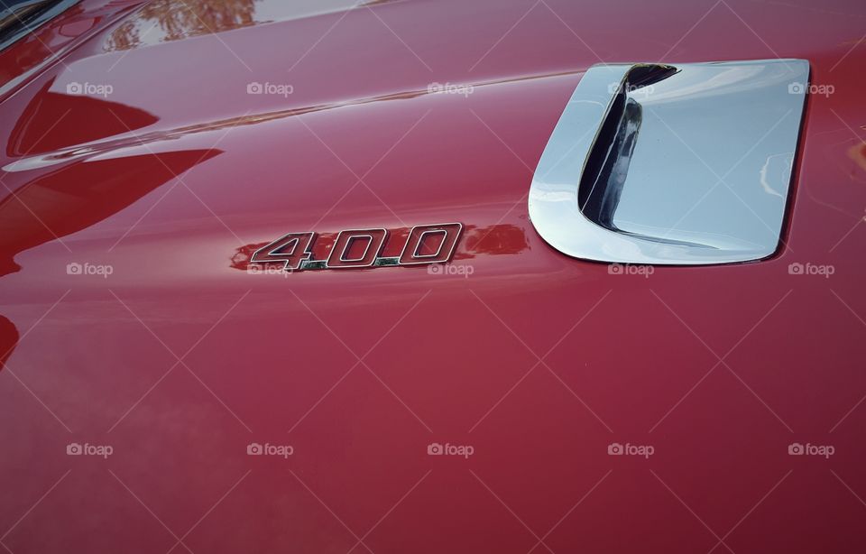 The hood of a classic red Pontiac Firebird 400.