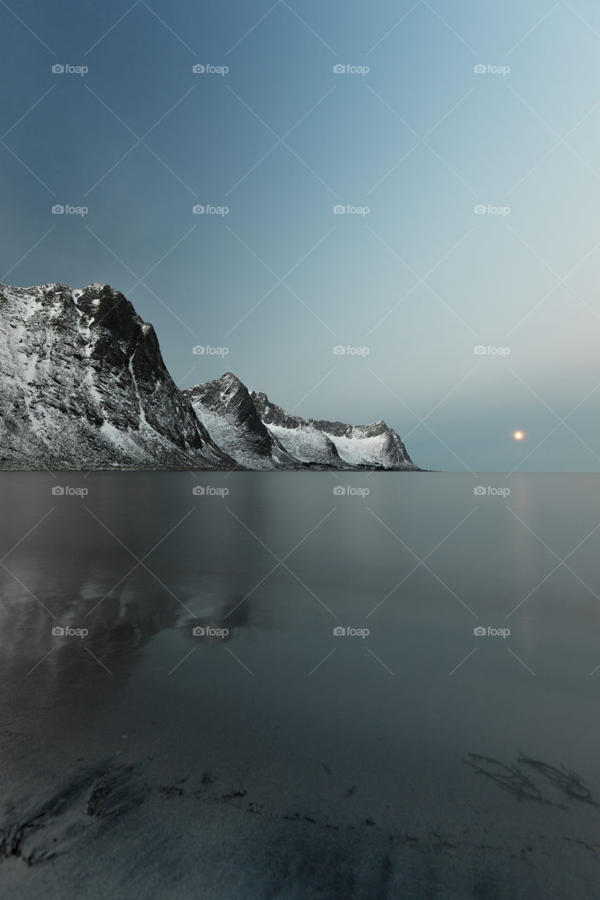 The full moon setting in Senja in the blue hour