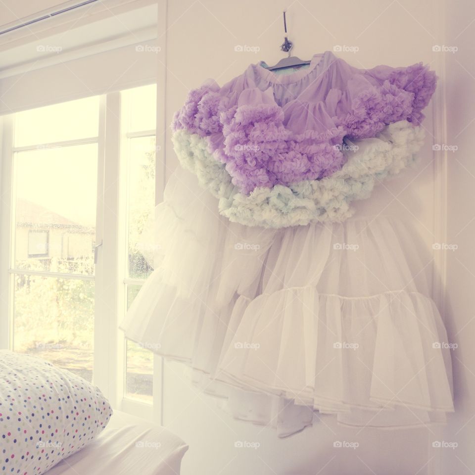 Purple and white dress hanging in a bedroom