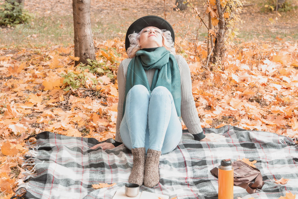 Portrait of middle aged adult woman relaxing in autumn forest