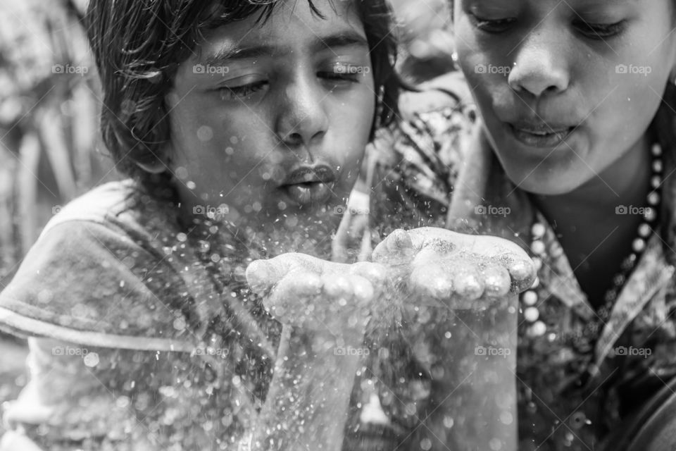 Two girls blowing glitters