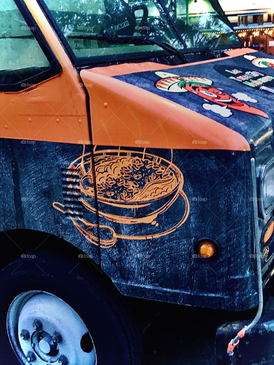 This is a close-up of the front part of the bright orange and dark blue truck that houses the taco stand in Long Island City, Queens, NY at the corner of 48th Street and Vernon Jackson Avenue. The photo is from July 2021. Hypnotic Productions