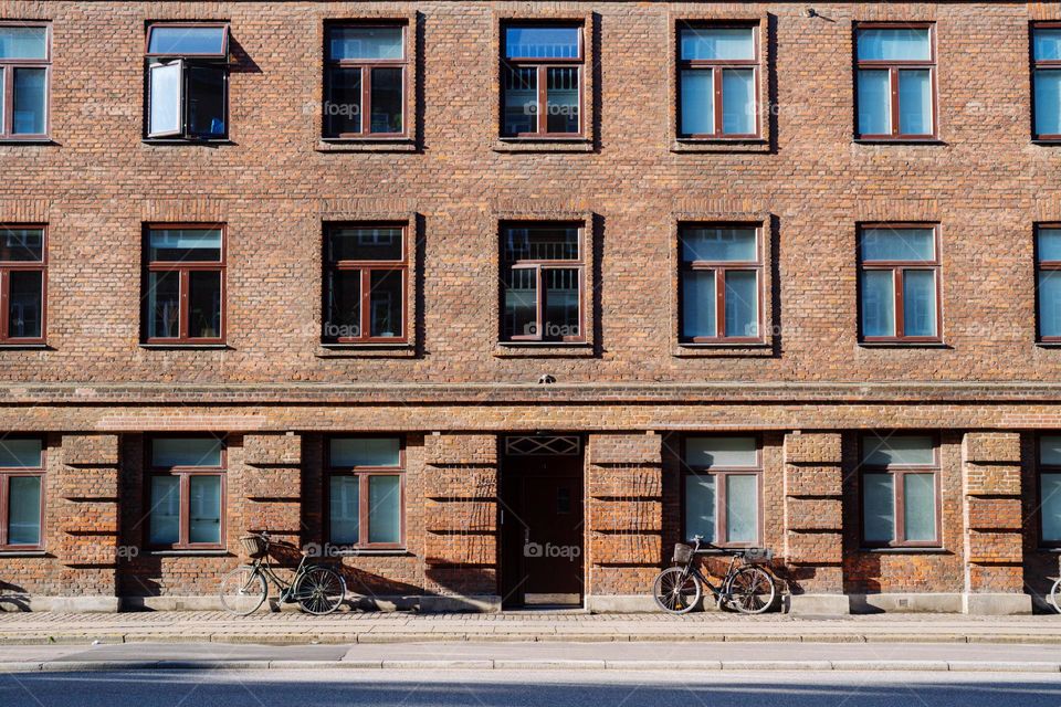 Bicycles parked by the brick building