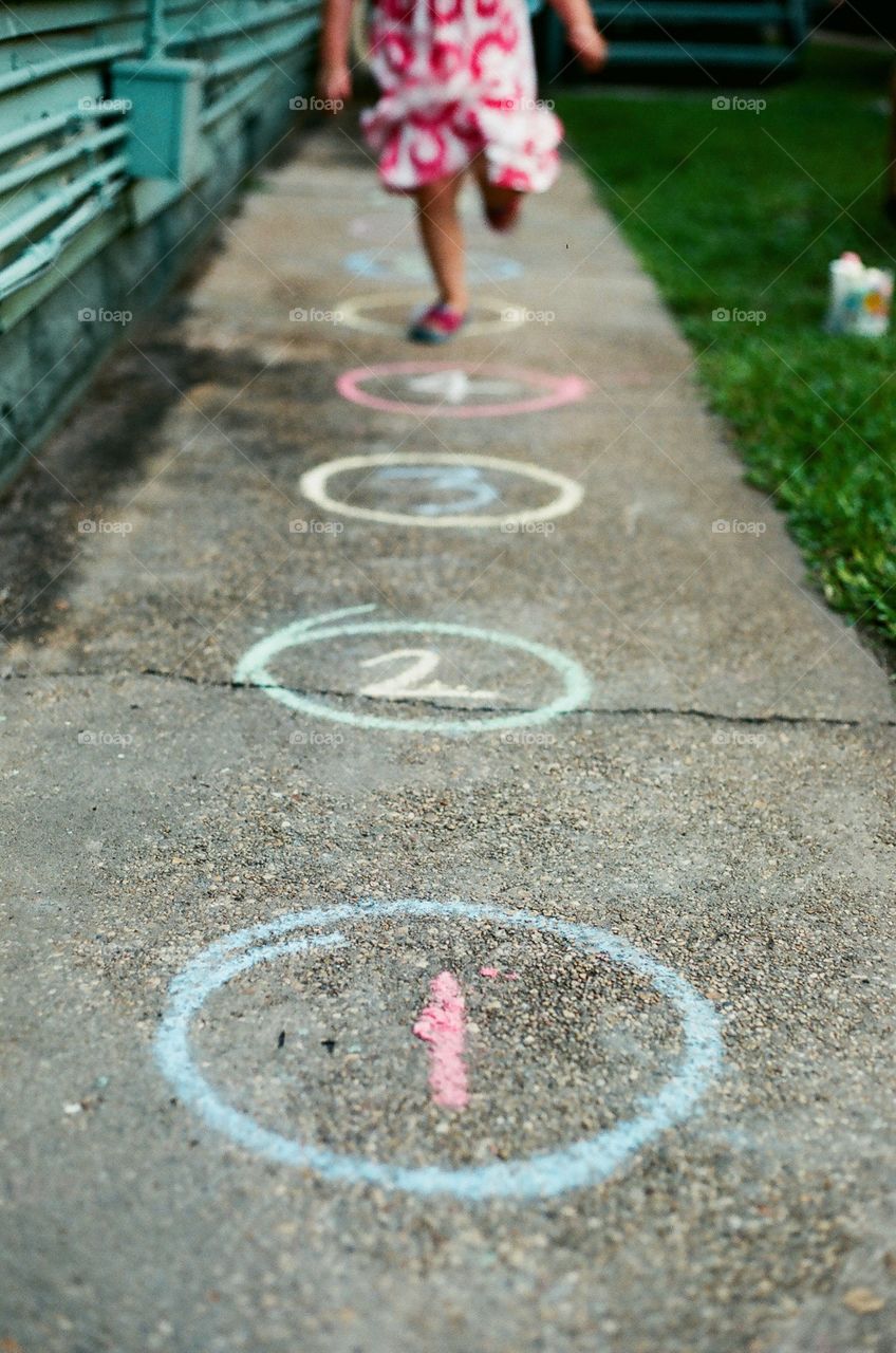 Girl playing sidewalk game made of chalk taken in New Orleans, La. photo is photog's daughter's feet. 