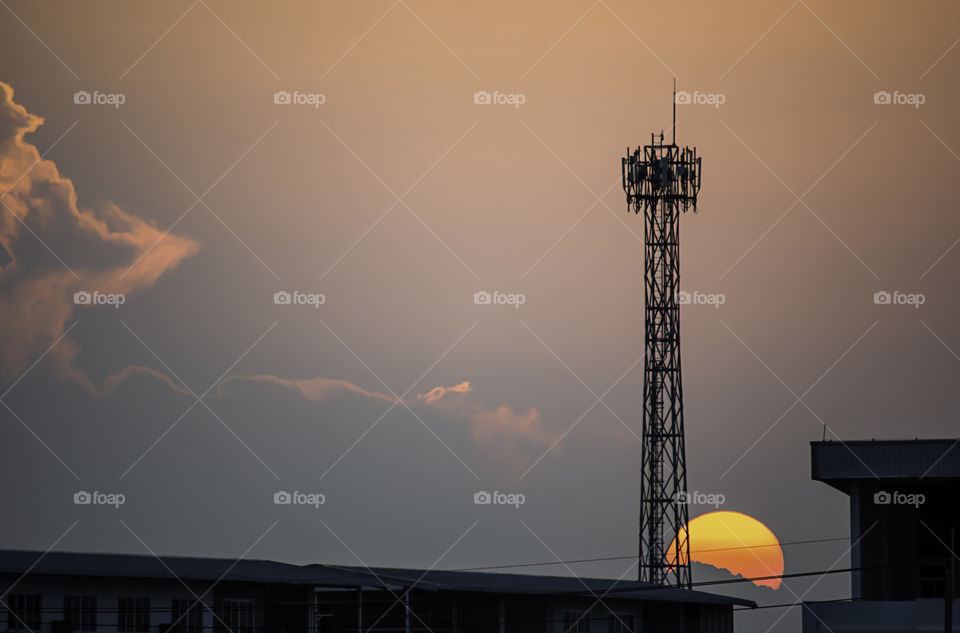 Evening sunset light is orange after the telephone receiver antenna.