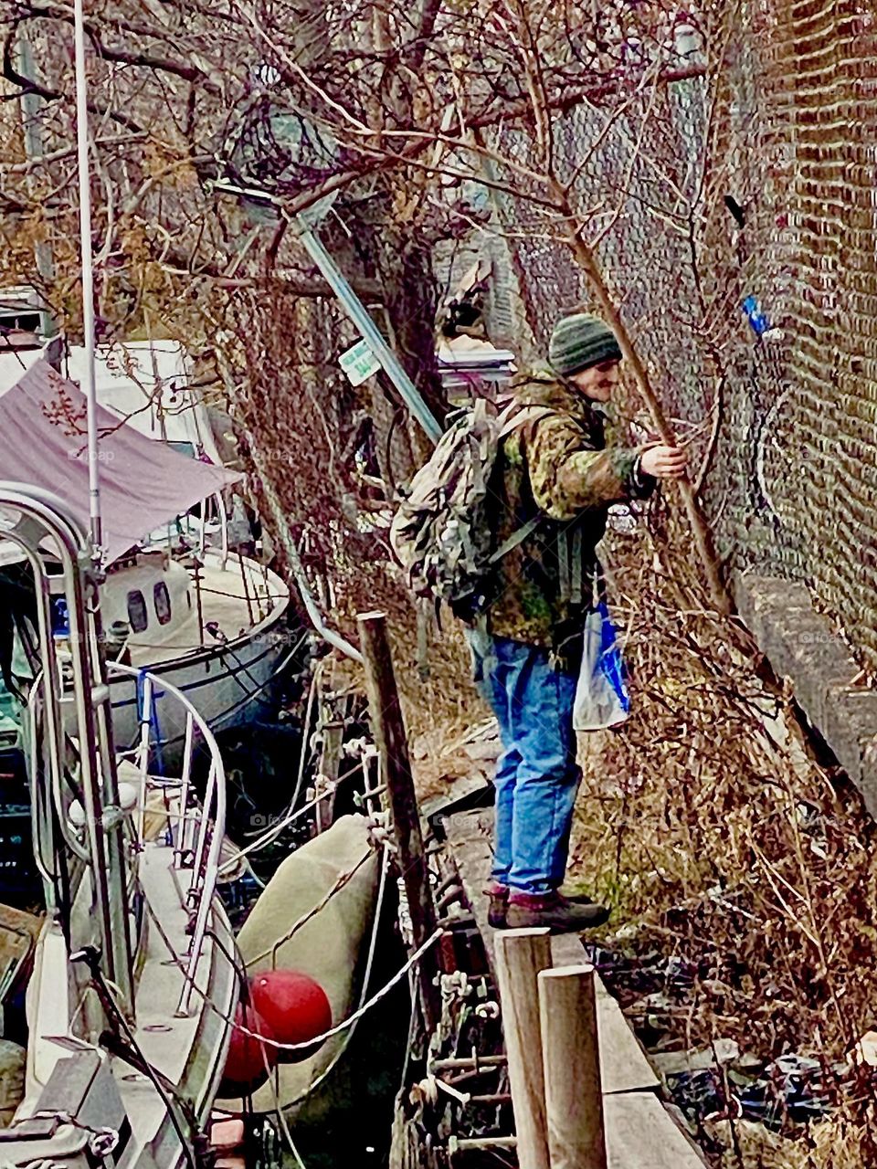 Timothy Trespas walking along the wall on the shore to get to our boat, the “Salvation” at Newtown Creek in Long Island City, Queens, NY. 2021. Hypnotic Productions