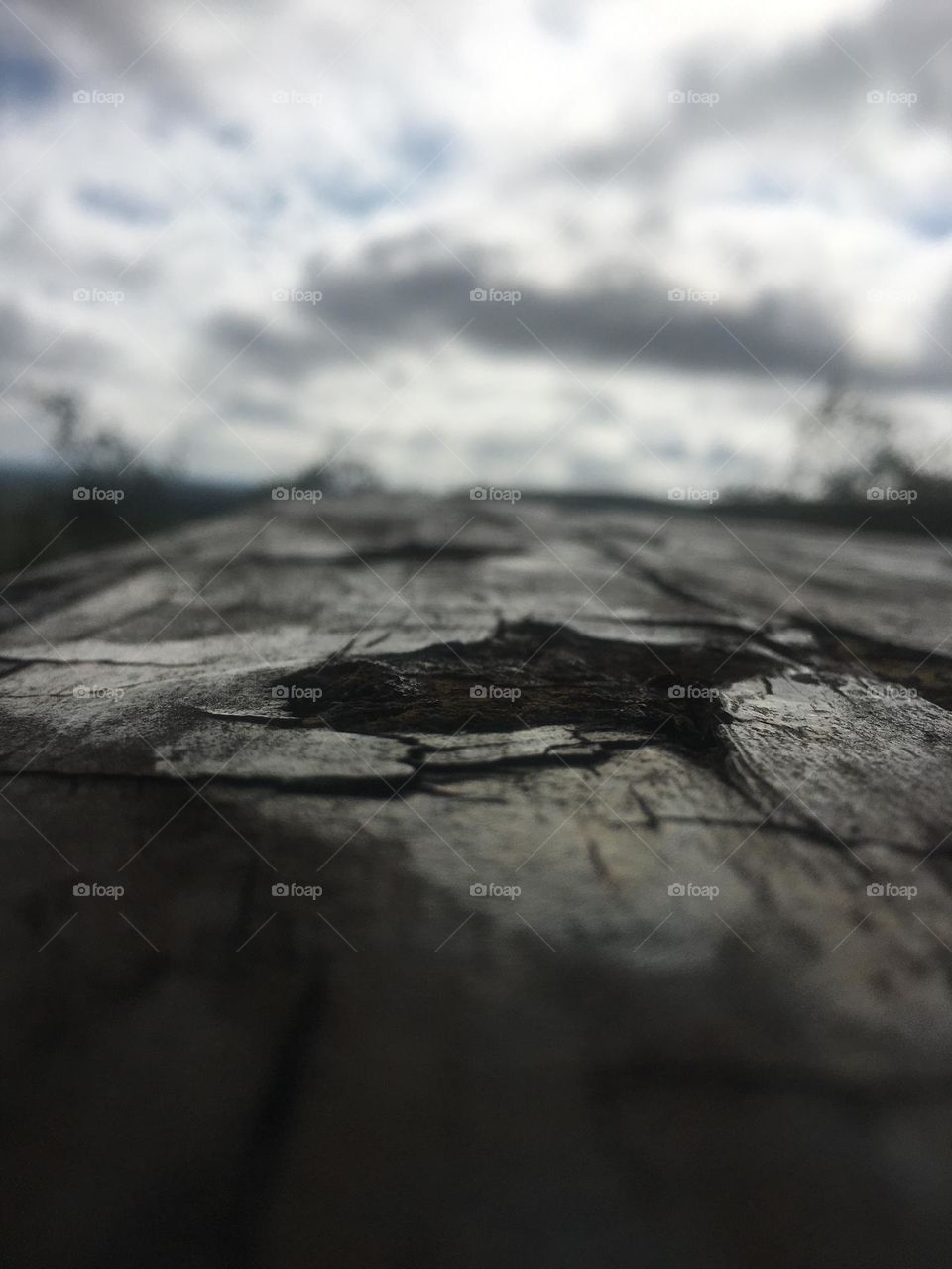 Wood bench closeup with clouds in the background 