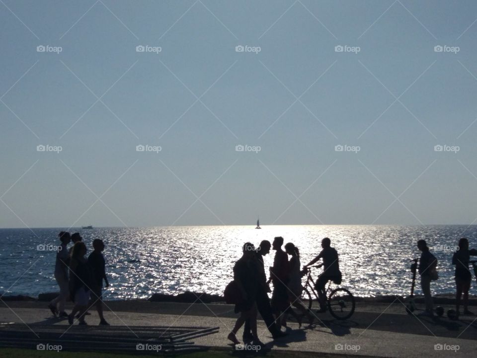 Mens and womens walk along the promenade at sunset