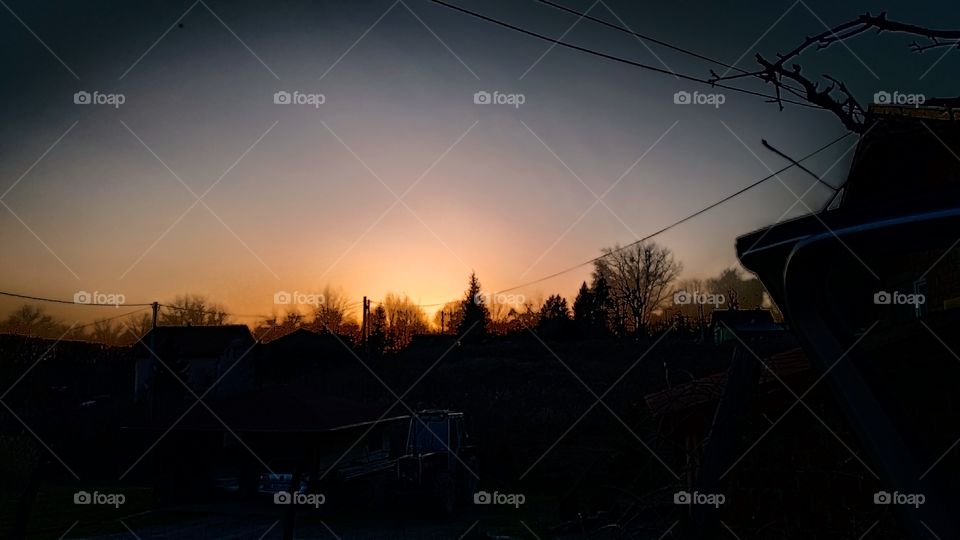 the sun sets behind the hill