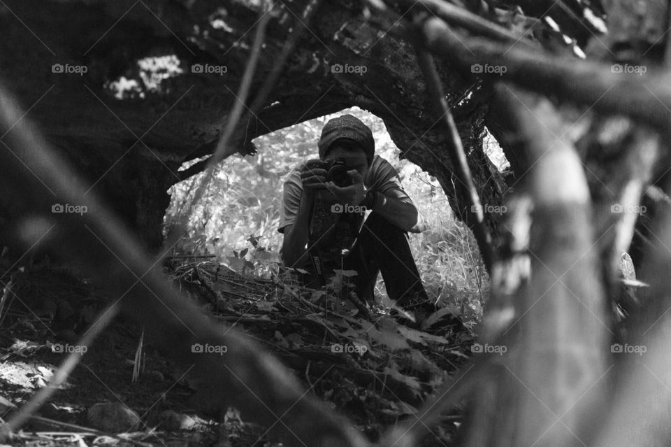 Photographed a photographer through the ends of a fall hollow tree 