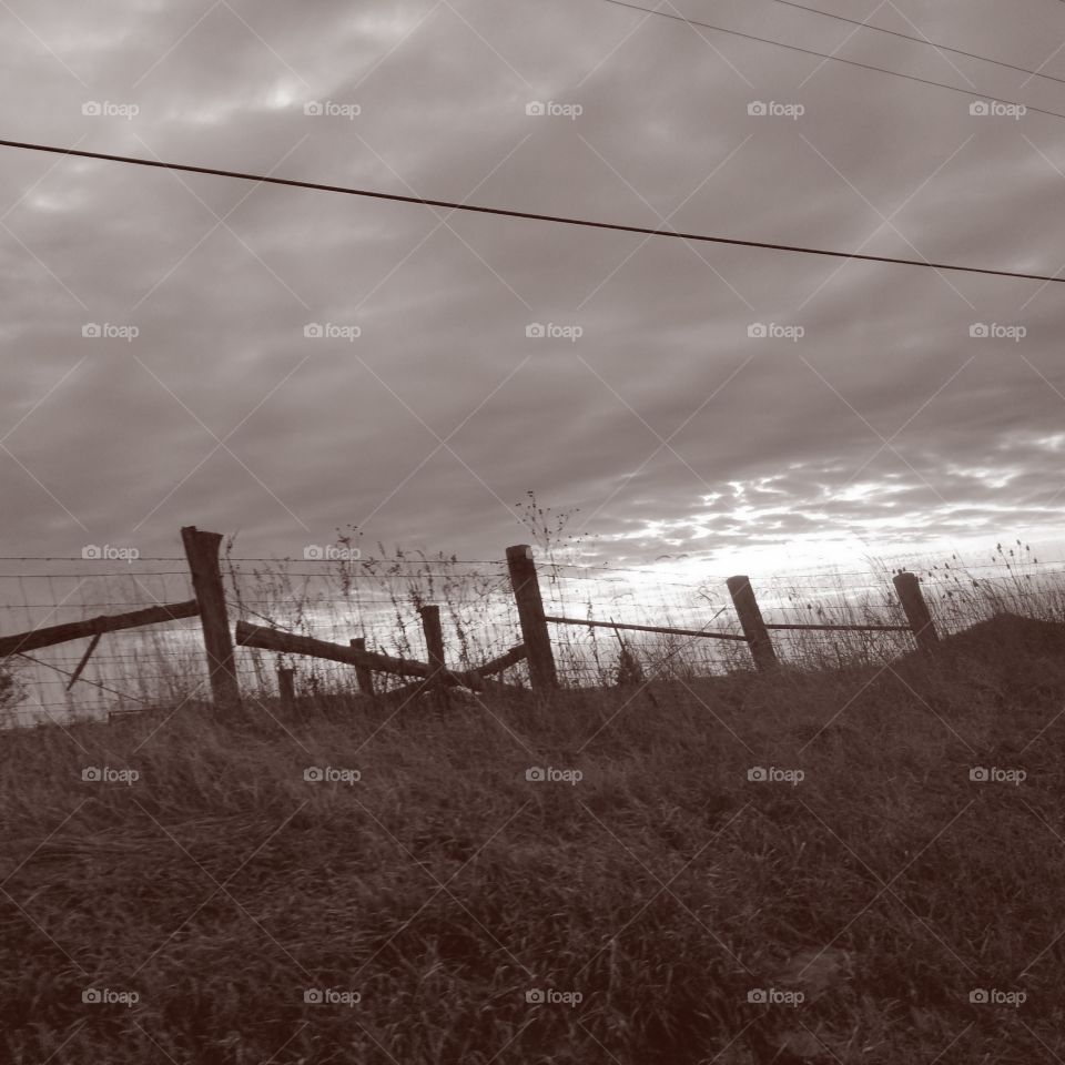 Old fence line against angry sky