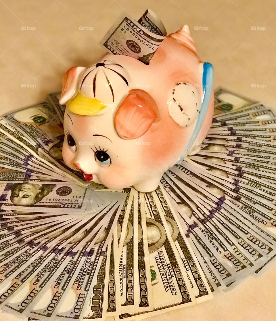 Piggy bank full of hundred dollar bills 