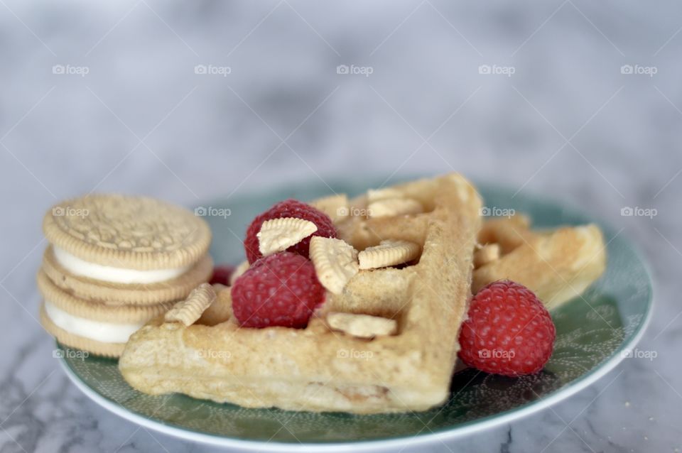 Golden double stuff Oreo cookies and a waffle with raspberries 