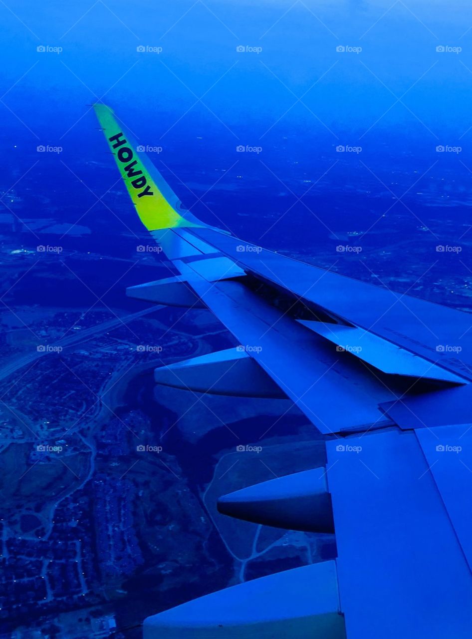 A spirit airlines wing as seen from the window. Special effects used to change colors.