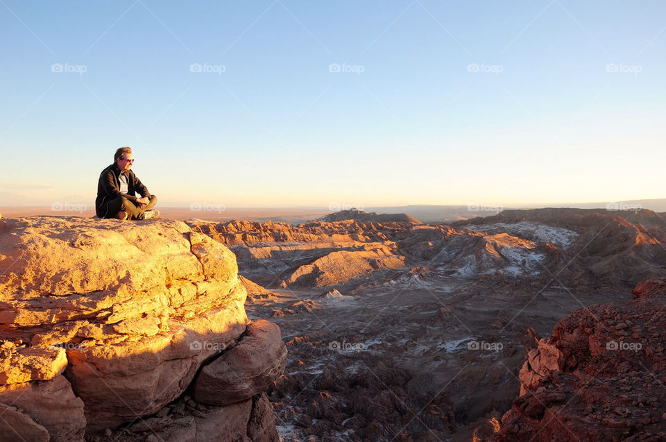 Man watching the sunset from a cliff