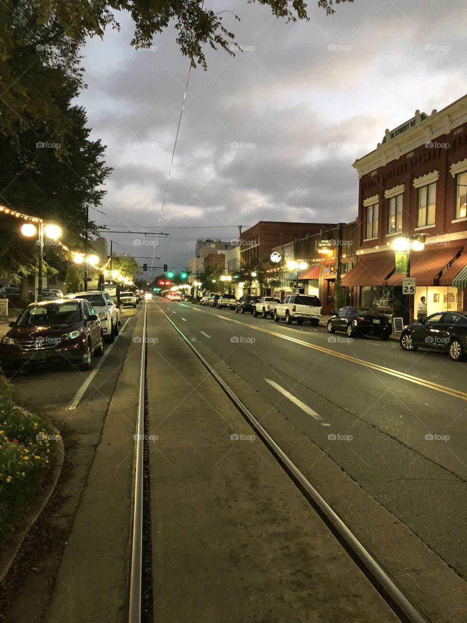 As gray storm clouds gather above, the bustling Argenta district prepares for an evening of dining out and nightlife as the street lights provides golden beams of light on the streets below. 