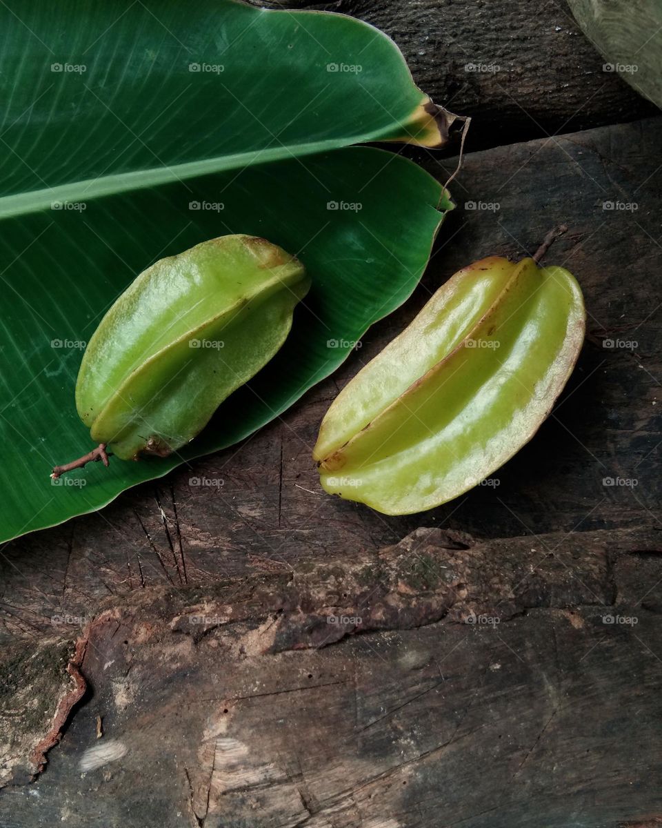 star fruits on leaf and wooden background