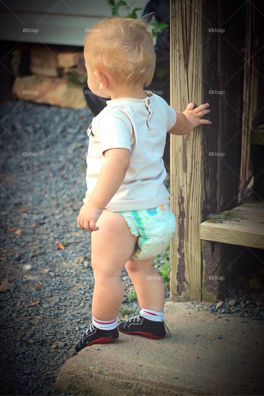 Old Wooden Porch. Little boy holding on to an old wooden porch. 