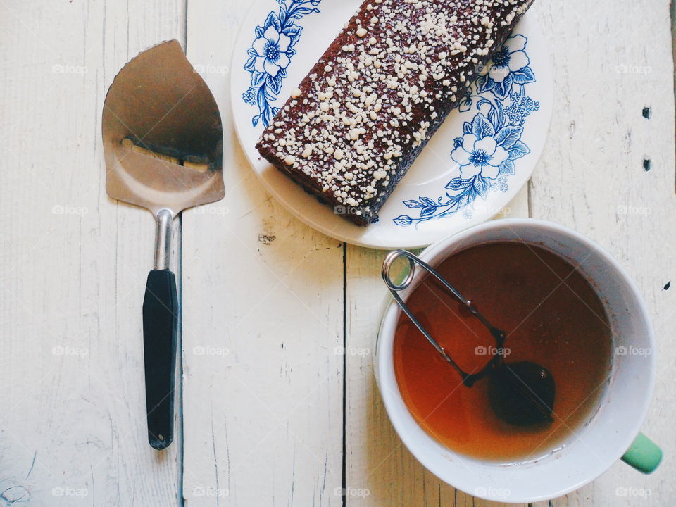 chocolate roll and a cup of black tea on a white background