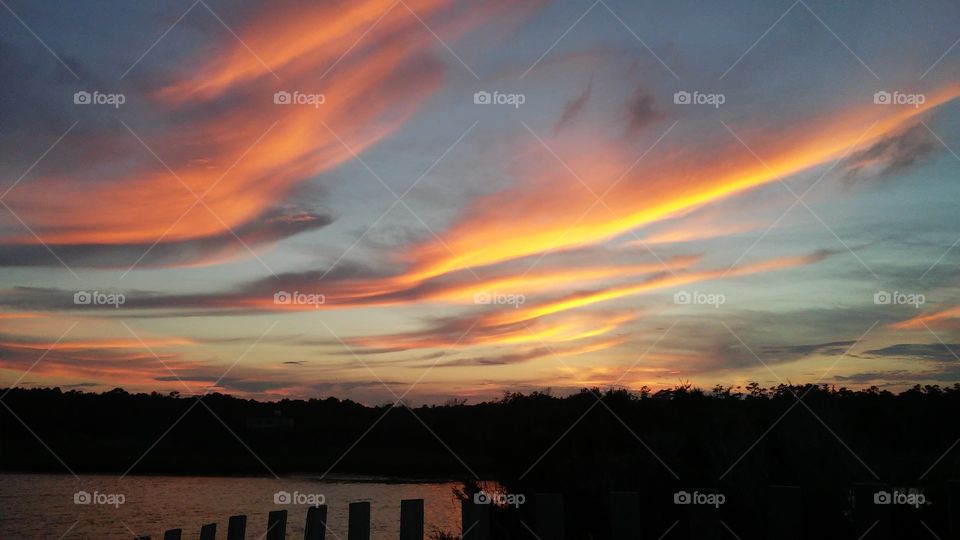 clouds look like birds soaring into the sunset over Pawleys Island SC salt marsh