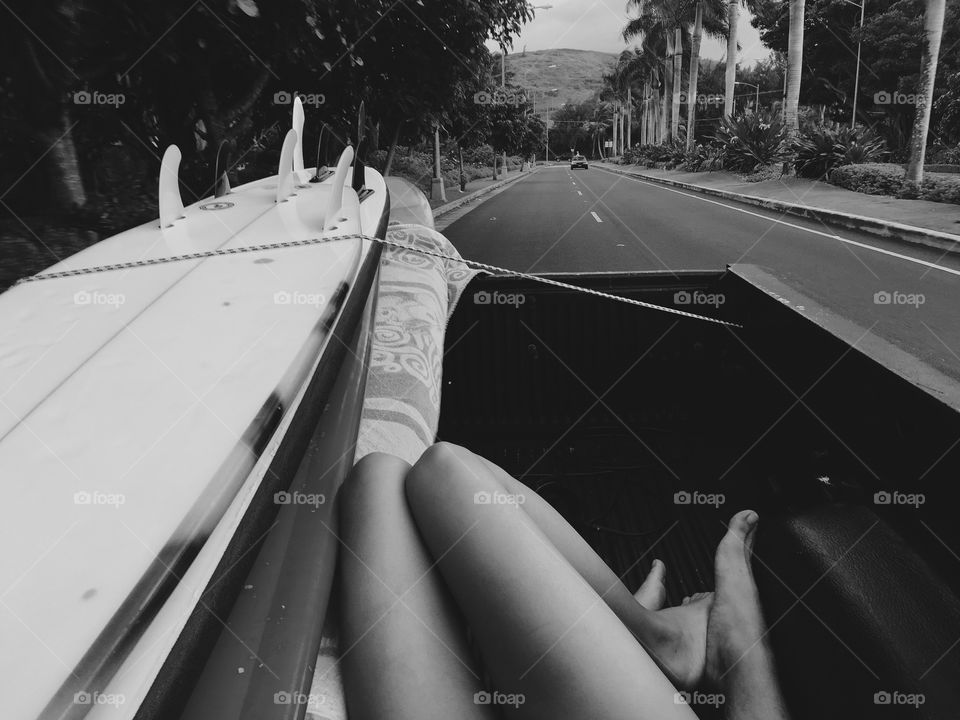 Couple laying in the back of a truck after a surf session on the north shore of Oahu.