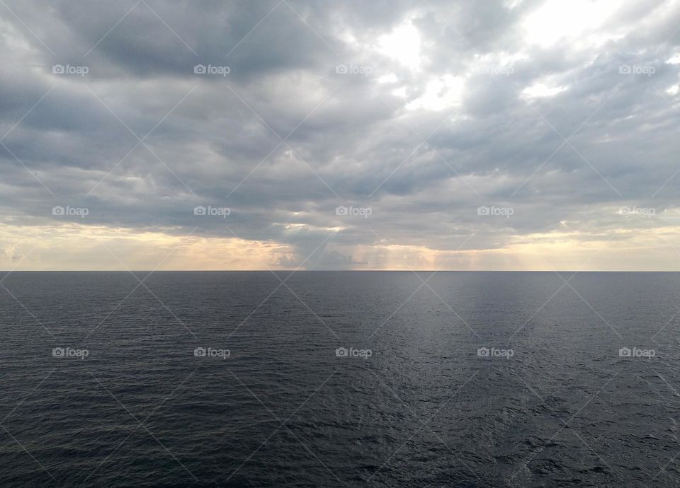 View of the sky among thick clouds, sea and morning sun.