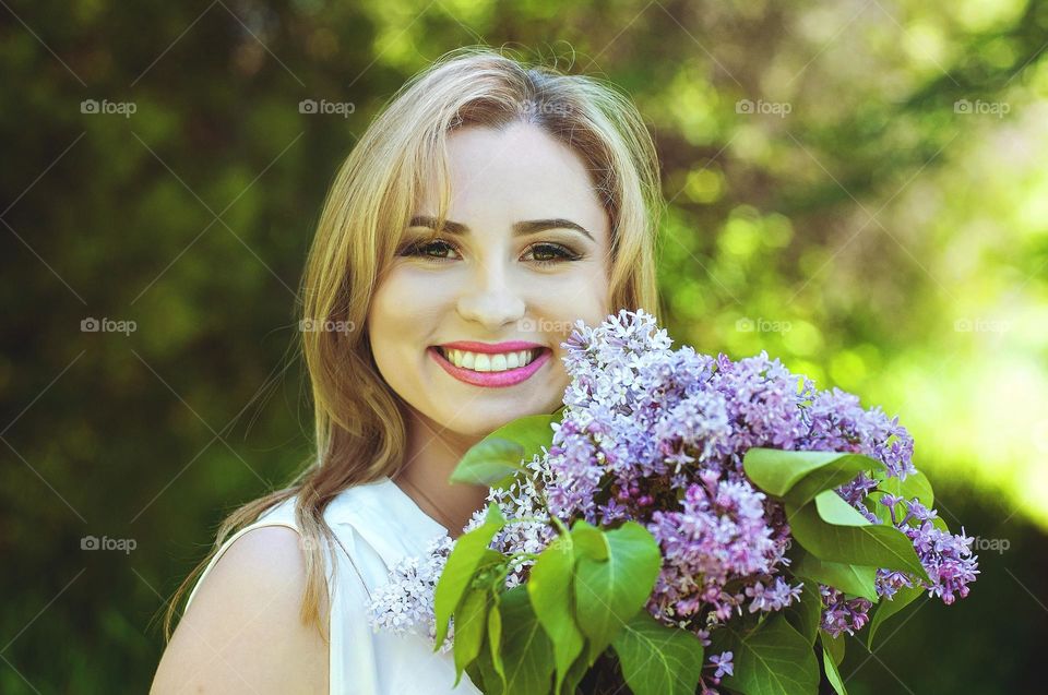 Close up portrait of beautiful smiling blonde woman with beautiful long hair and brown eyes.  Spring season