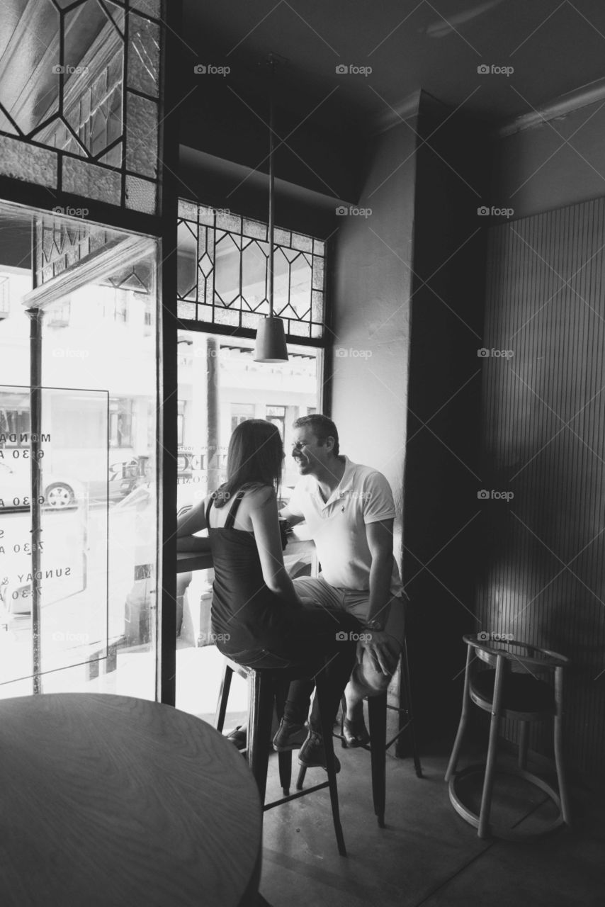 A couple laughing in a coffee shop
