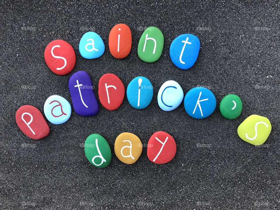 Sain Patrick’ day with multicolored stones over black volcanic sand 