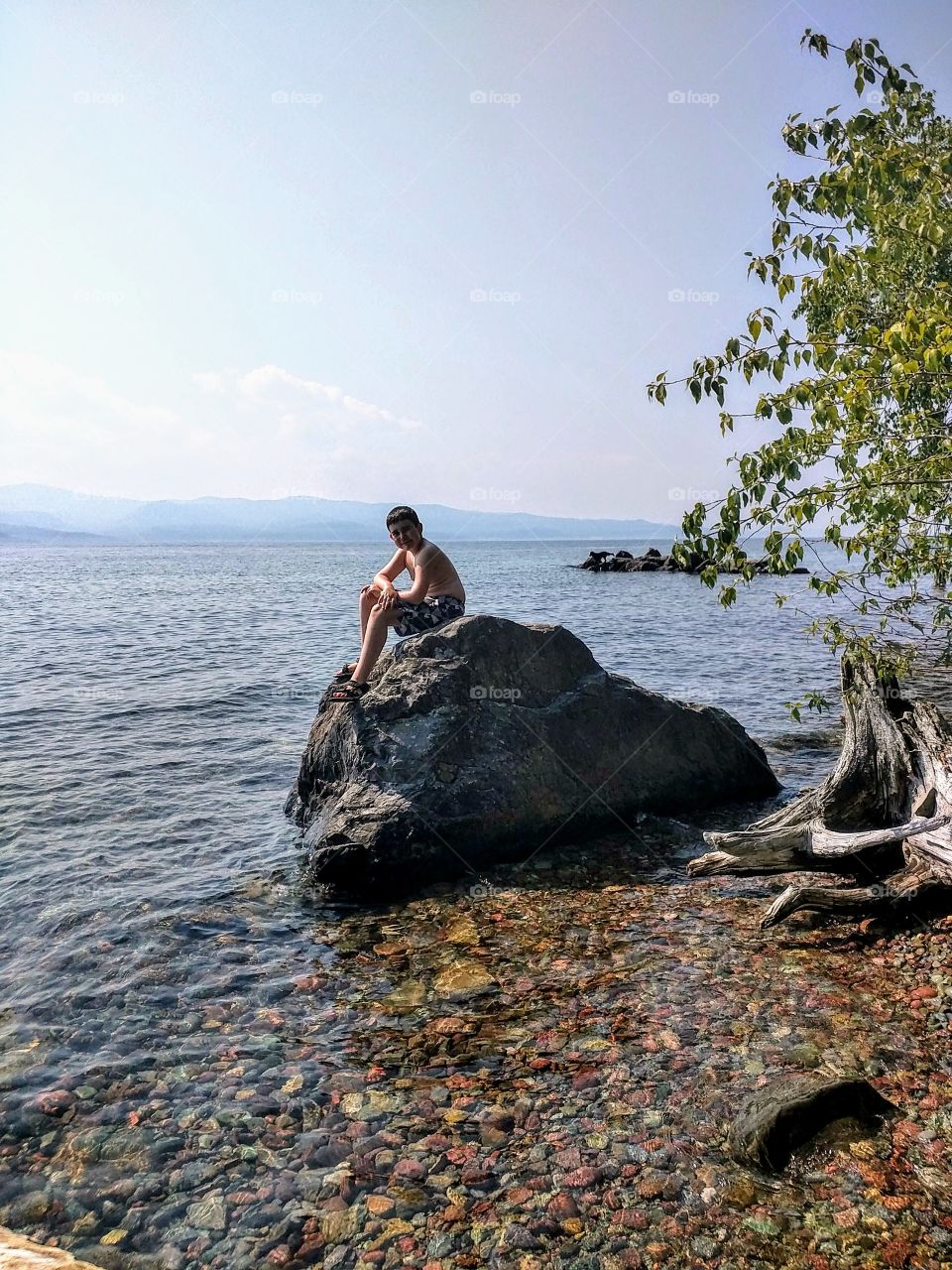 Sitting on the rock at Woods Bay, Flathead Lake, MT