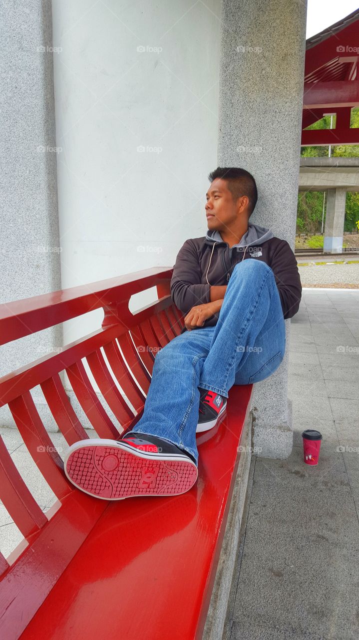 Contemplating on a red bench