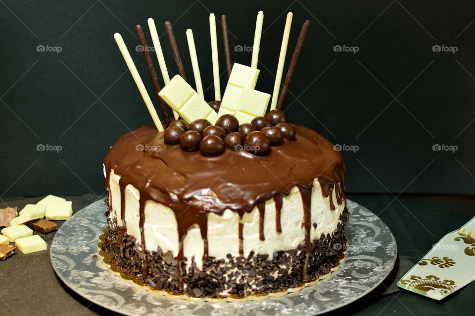 delicious drip cake with various types of chocolate: dark, white and milk