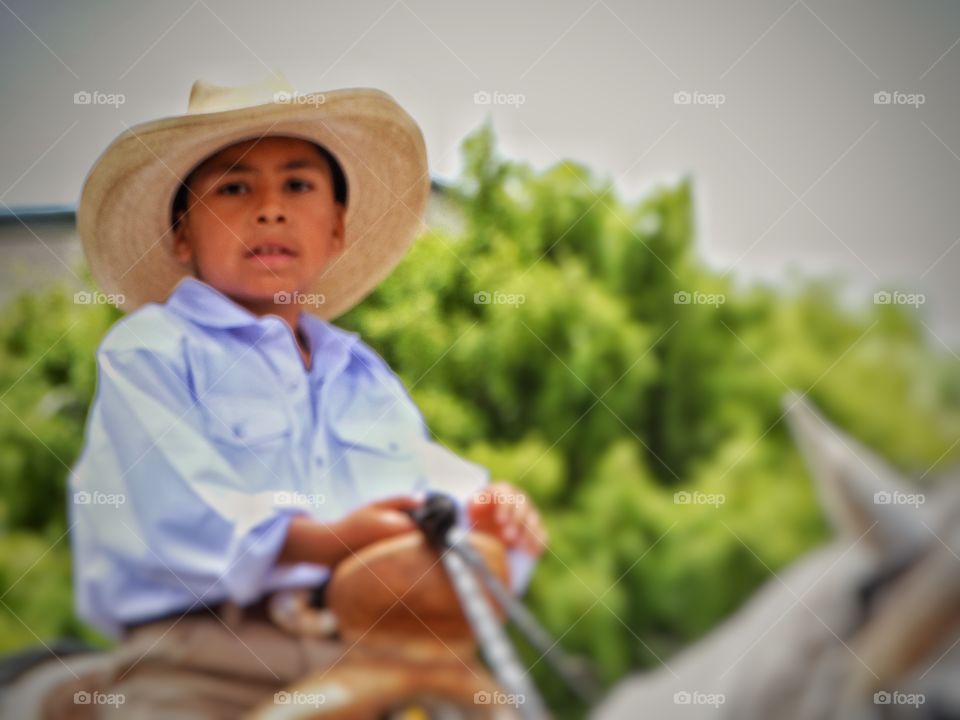 Young Cowboy. Young Mexican Boy Riding A Horse
