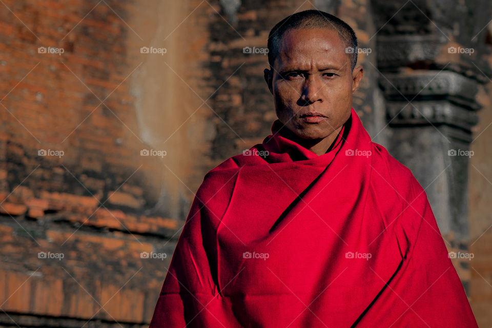 A Burmese monk stands outside his temple of worship