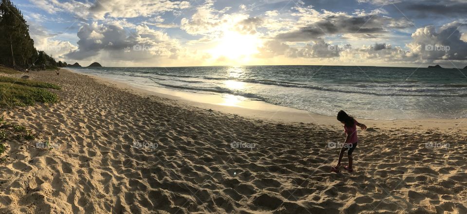 Panoramic; girl playing on the beach; Hawaiian sunrise