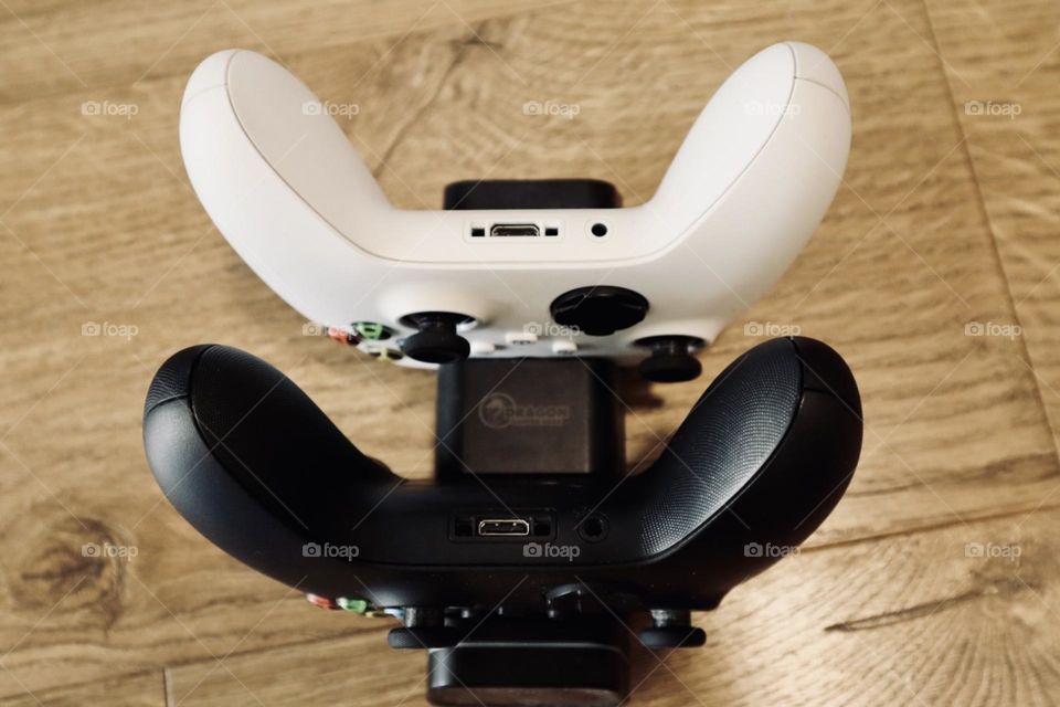 Xbox black and white controllers in a charger 