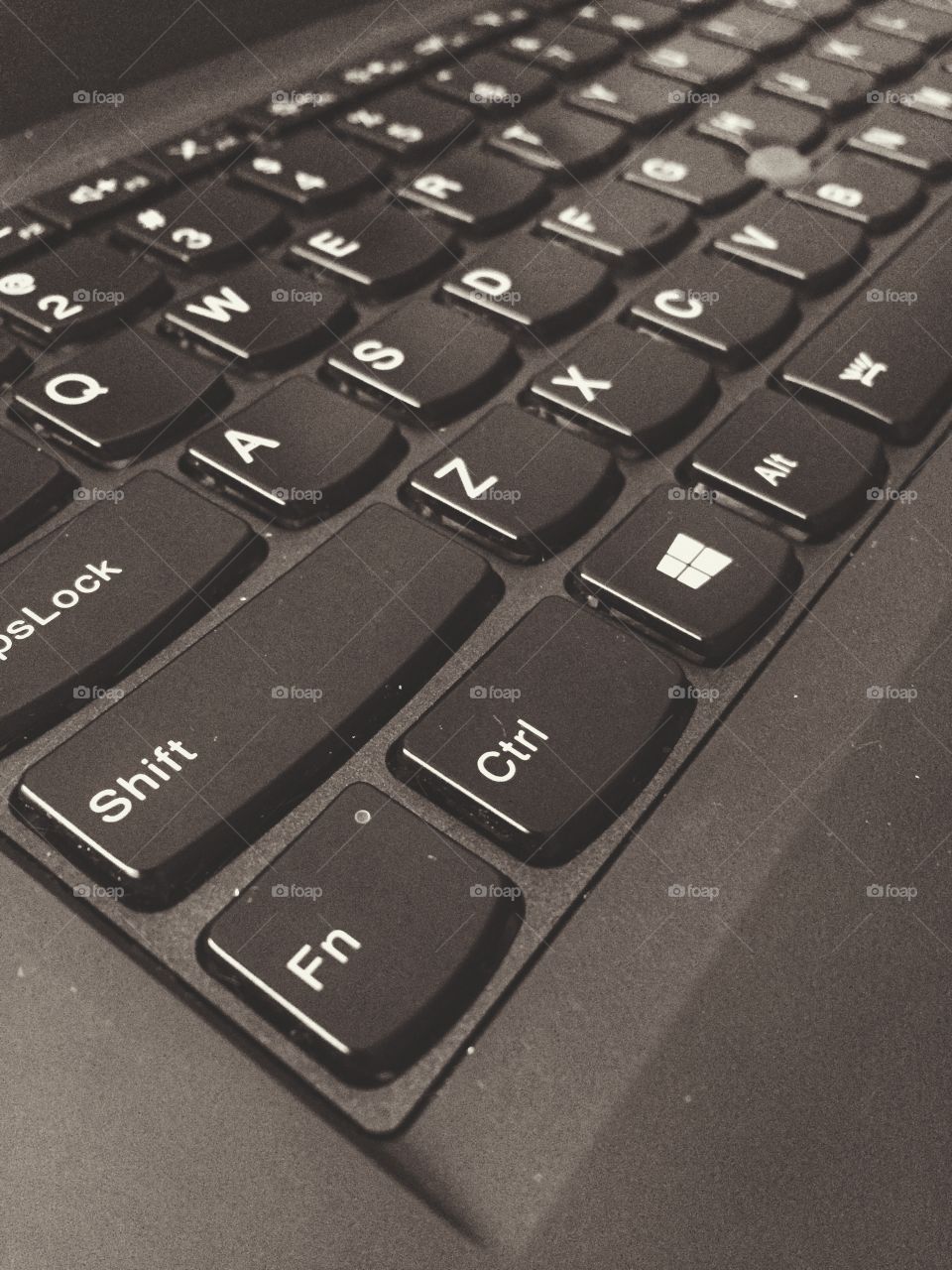 A keyboard from a modern laptop. It is black and focuses on the bottom left corner of the keyboard.