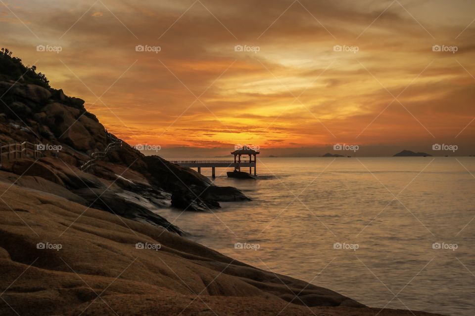 Break of Dawn at Long Chao Kok coastal Trail Macau, with a Passing Light Vessel framed on a Gazebo.