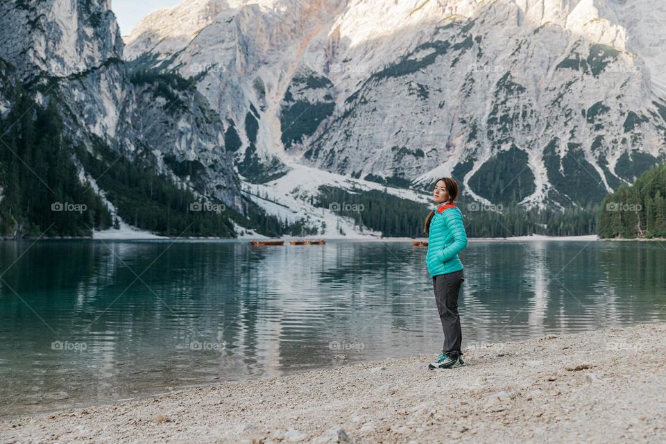 Woman admiring the beautiful area of Lago di Braies, located in the Dolomites-Italy.