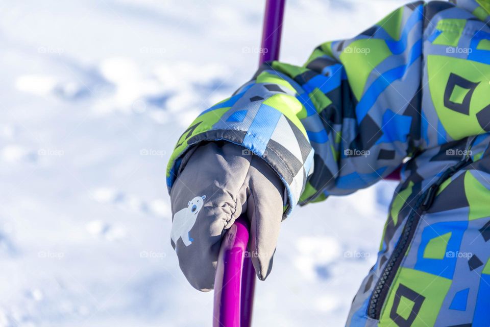 A child's hand in a mitten in winter.