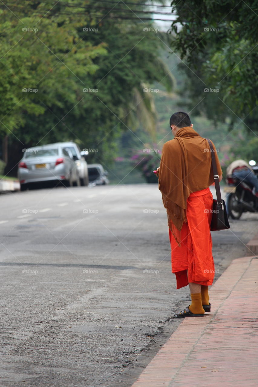 Monk waiting at Luang Prabang Laos January 2016
