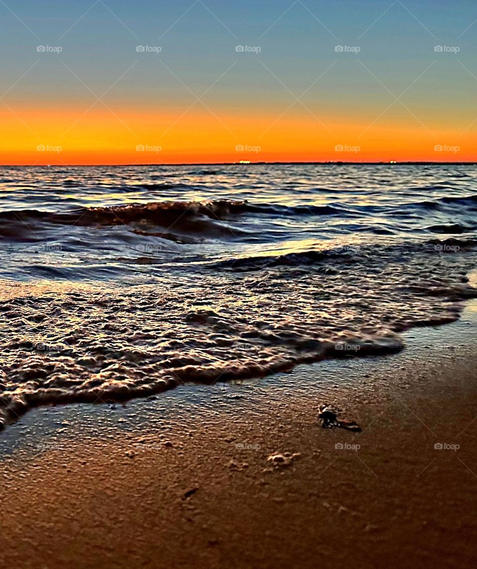 A breathtaking and radiant sunset which colors the waves iridescent, often towers and collides the shore with great force. The impact of the waves against the coastline created a stunning display of energy and motion