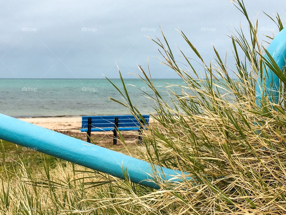 Aqua blue bench at the seashore, benches in remote places