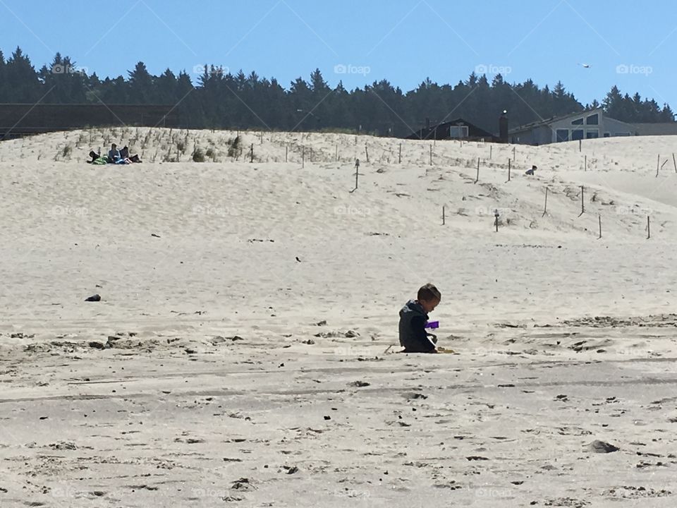 Cute boy playing in the dunes