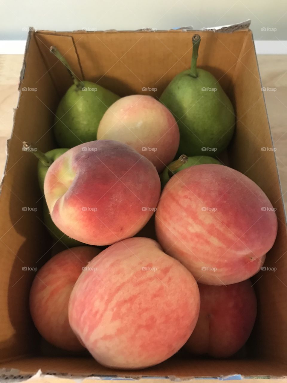 Box of orange peaches and green pears 