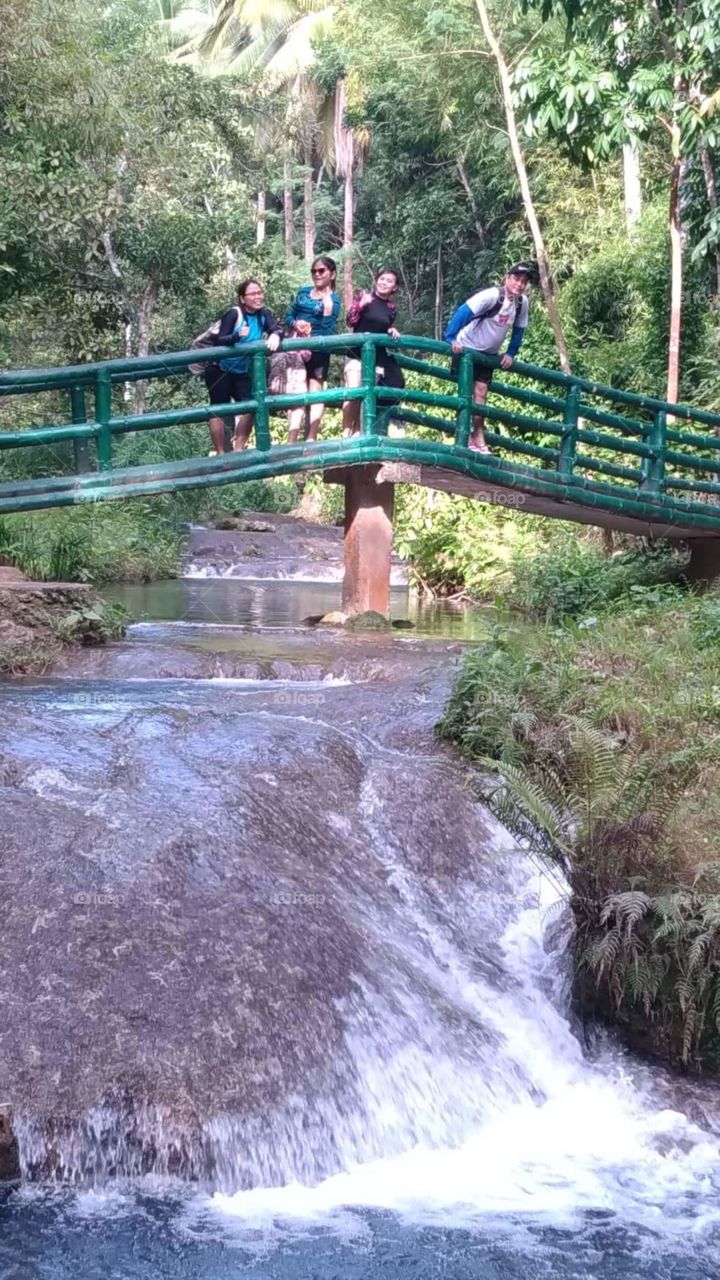 in waterfalls taking picture with friends