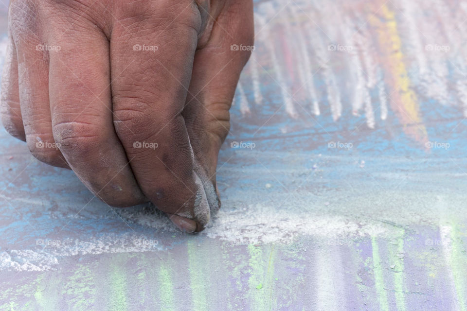 Street artist drawing with chalk on street