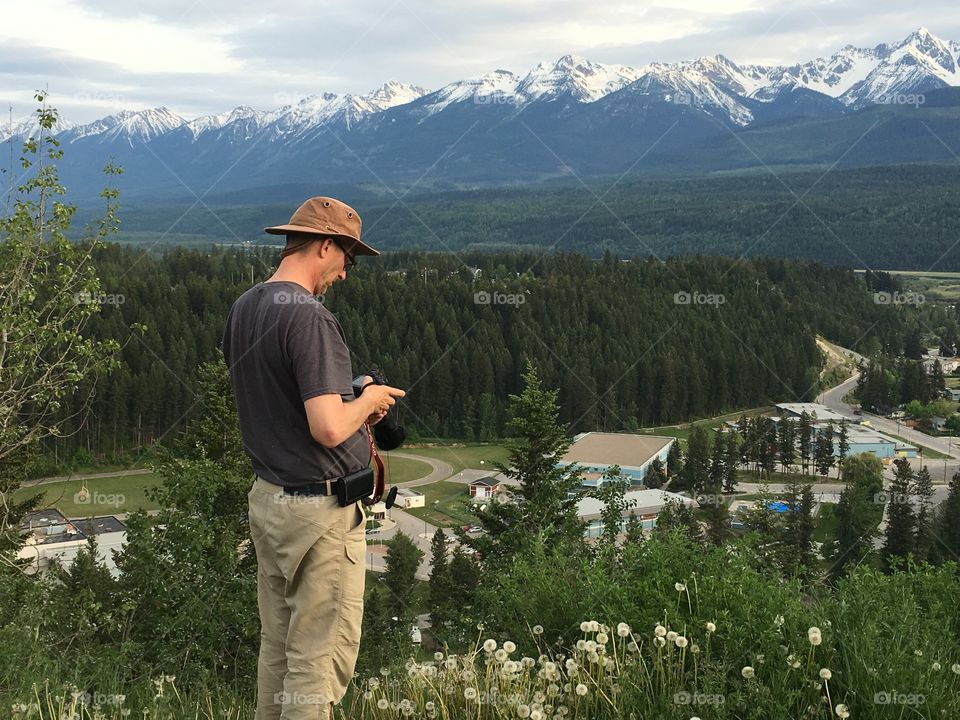 Man standing near forest holding camera