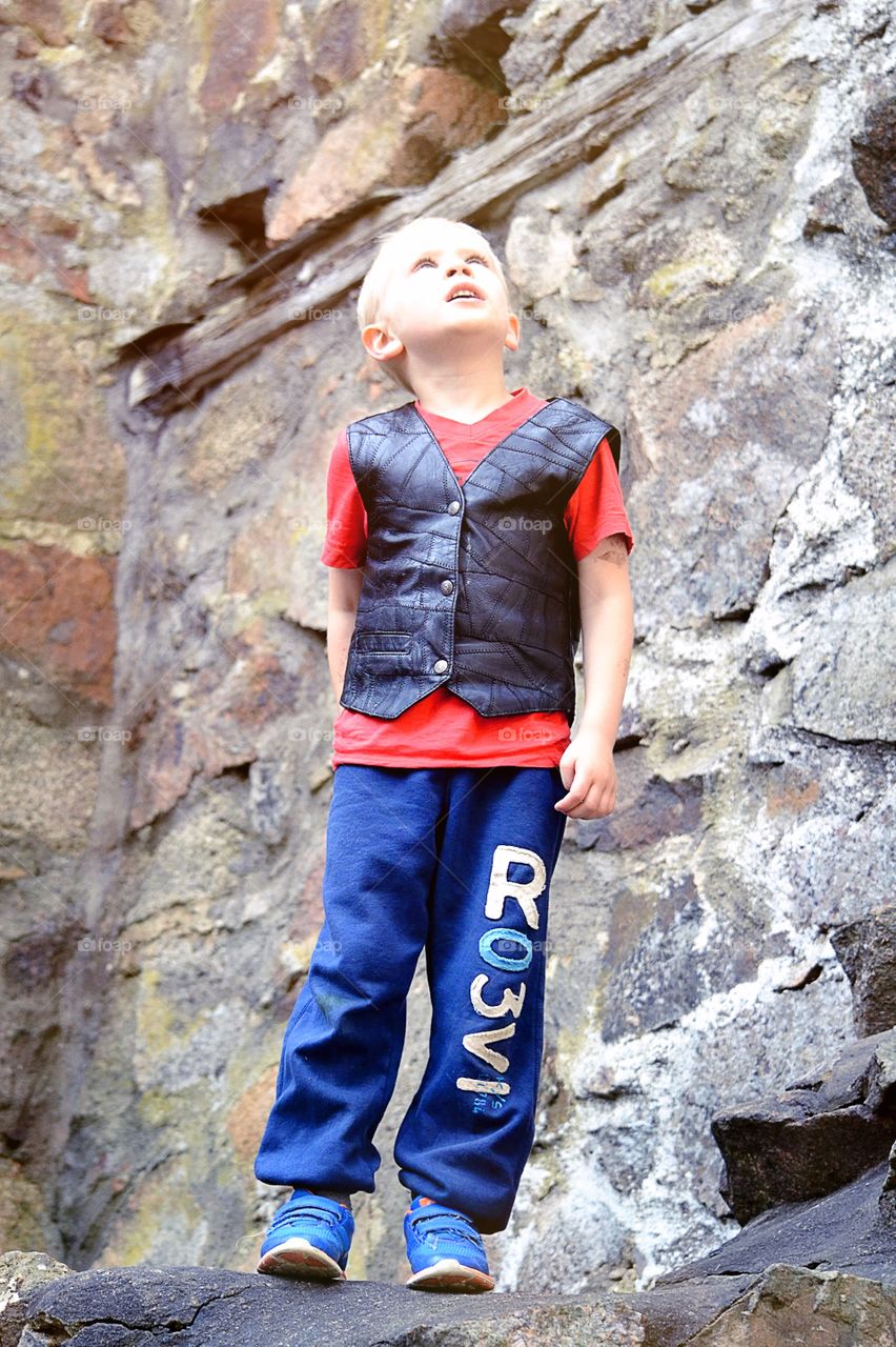 Looking up. Boy looking on old ruins